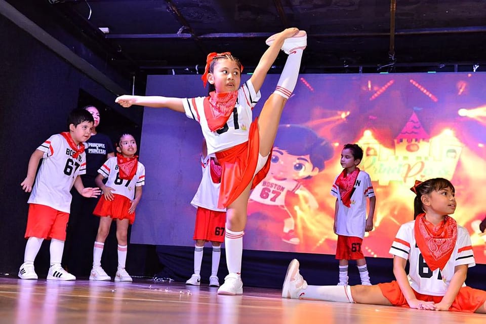 Alumnos en una presentación de danza con luces de escenario