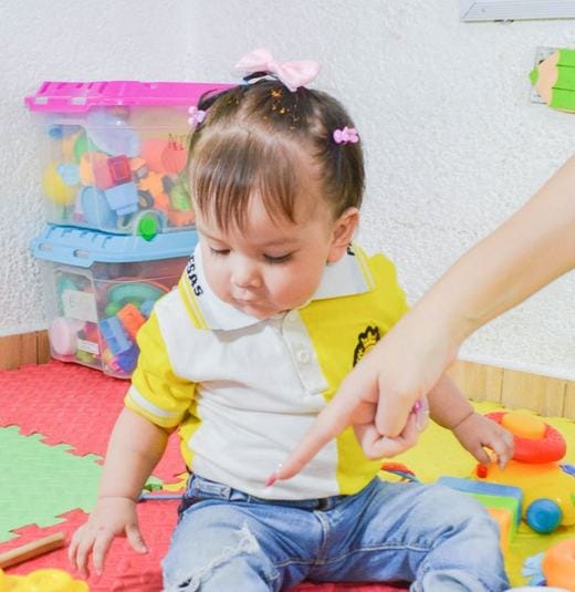 Bebé explorando juguetes en la sala de juegos de la guardería